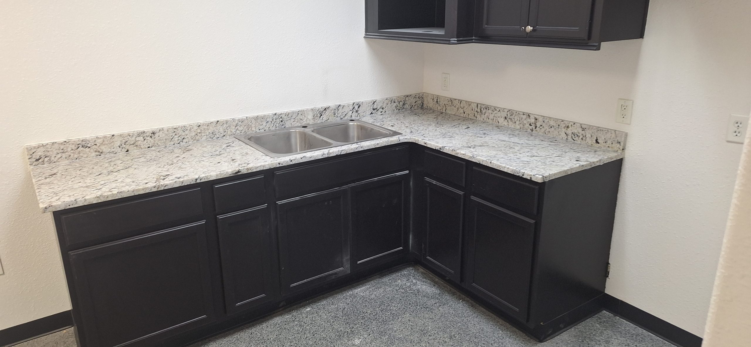 | R&D Marble, Inc. an l-shaped corner kitchen with dark cabinets and stone countertops