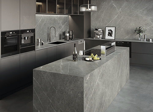 | R&D Marble, Inc. A grey marble backsplash, countertops, and island in a luxurious kitchen.