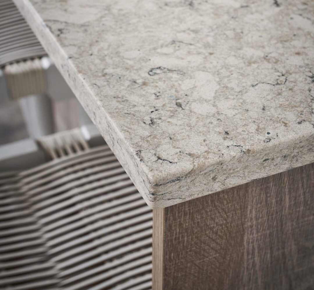 | R&D Marble, Inc. Close up of the corner of an eased edge quartz countertop in a modern kitchen.