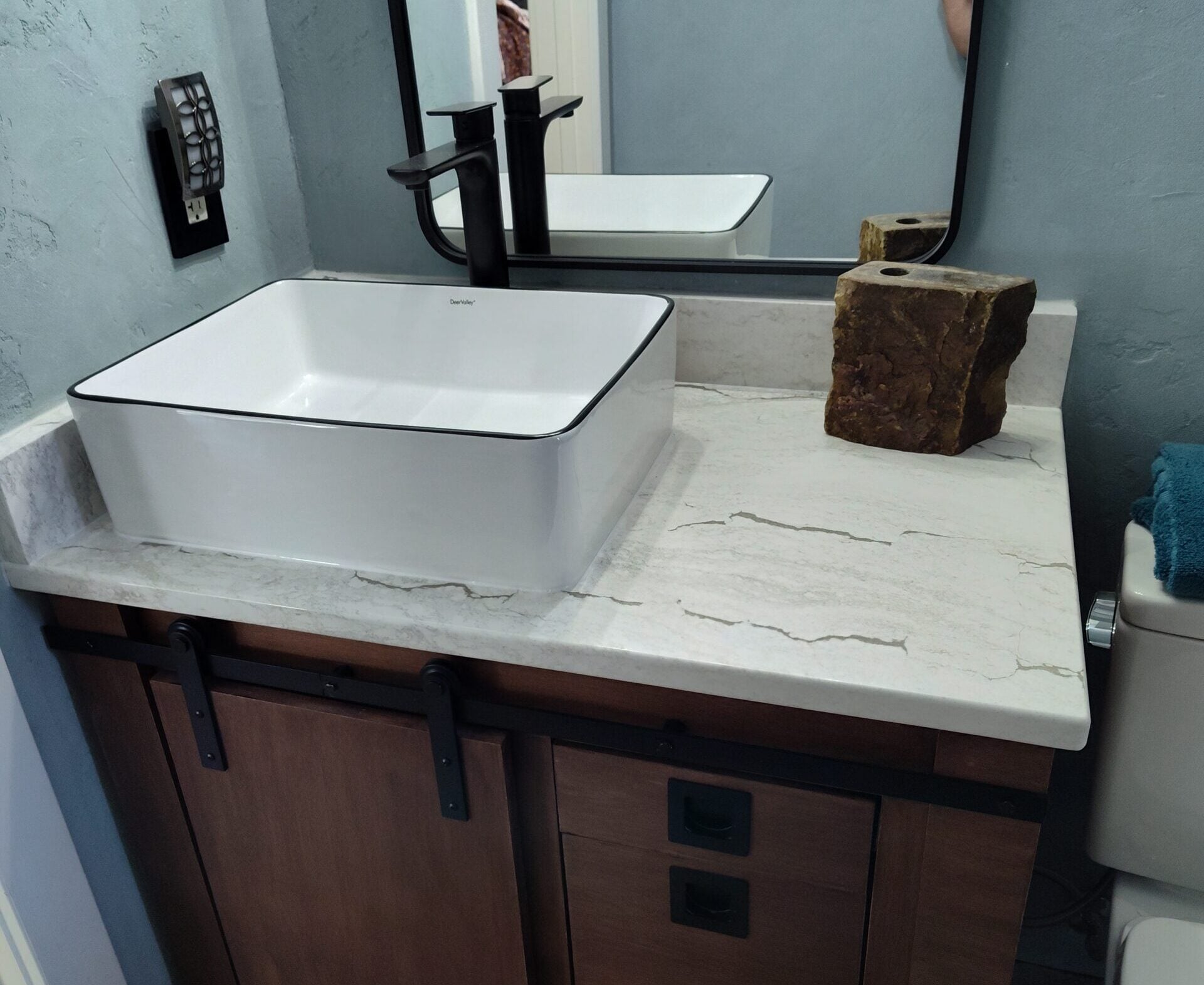 Bathroom Countertop Materials for Style and Durability Guide A custom bathroom vanity with modern stone countertop, elevated sink, and dark brown cabinetry.