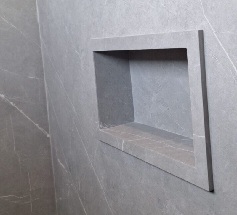 | R&D Marble, Inc. Gray marble shower wall with a square recessed niche/shelf area.